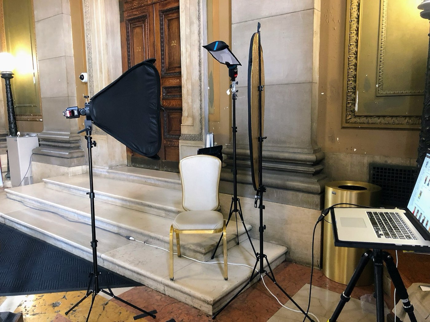 Marmeren trap en hal met softboxen, een stoel en een laptop