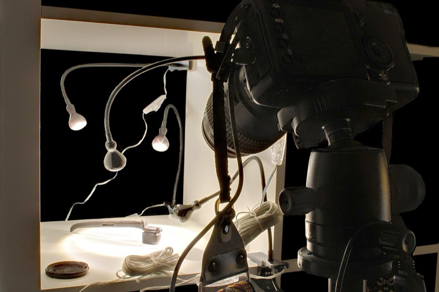 Macro-opstelling met een camera, kleine lampen en een sieraad op wit